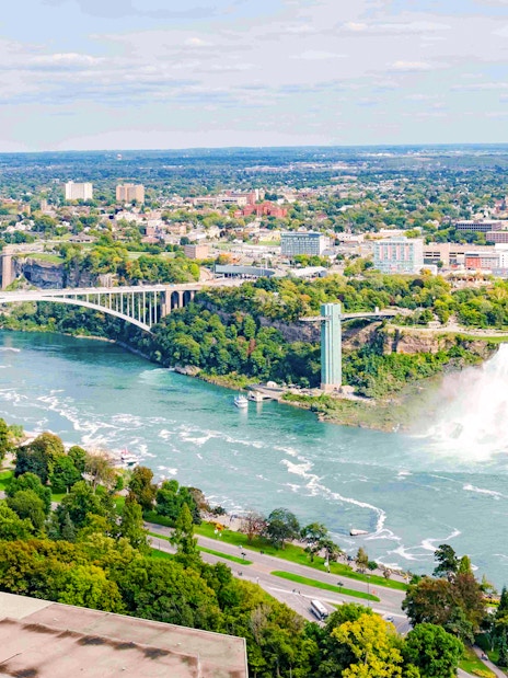 Skylon Tower with view of Niagara Falls and mist rising from the water.