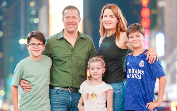 Family posing in Times Square, NYC during a photoshoot.