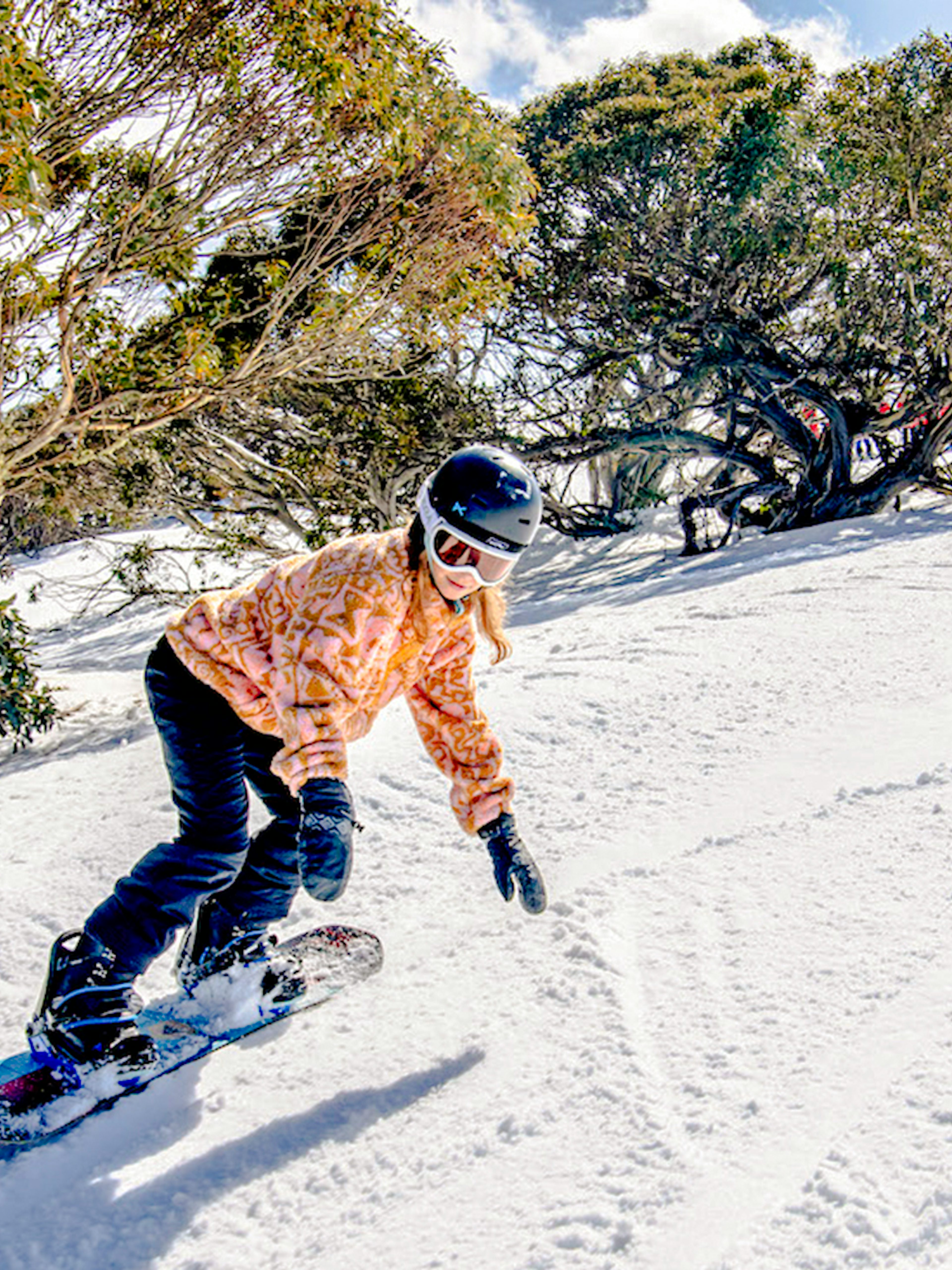 Snowboarder and skier on a snowy slope at Mt Buller, Australia.