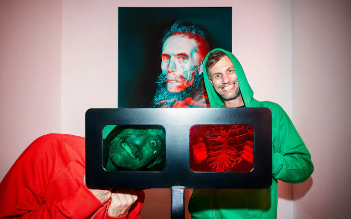 Visitors interacting with optical illusions at IAM Illusion Art Museum, Prague.