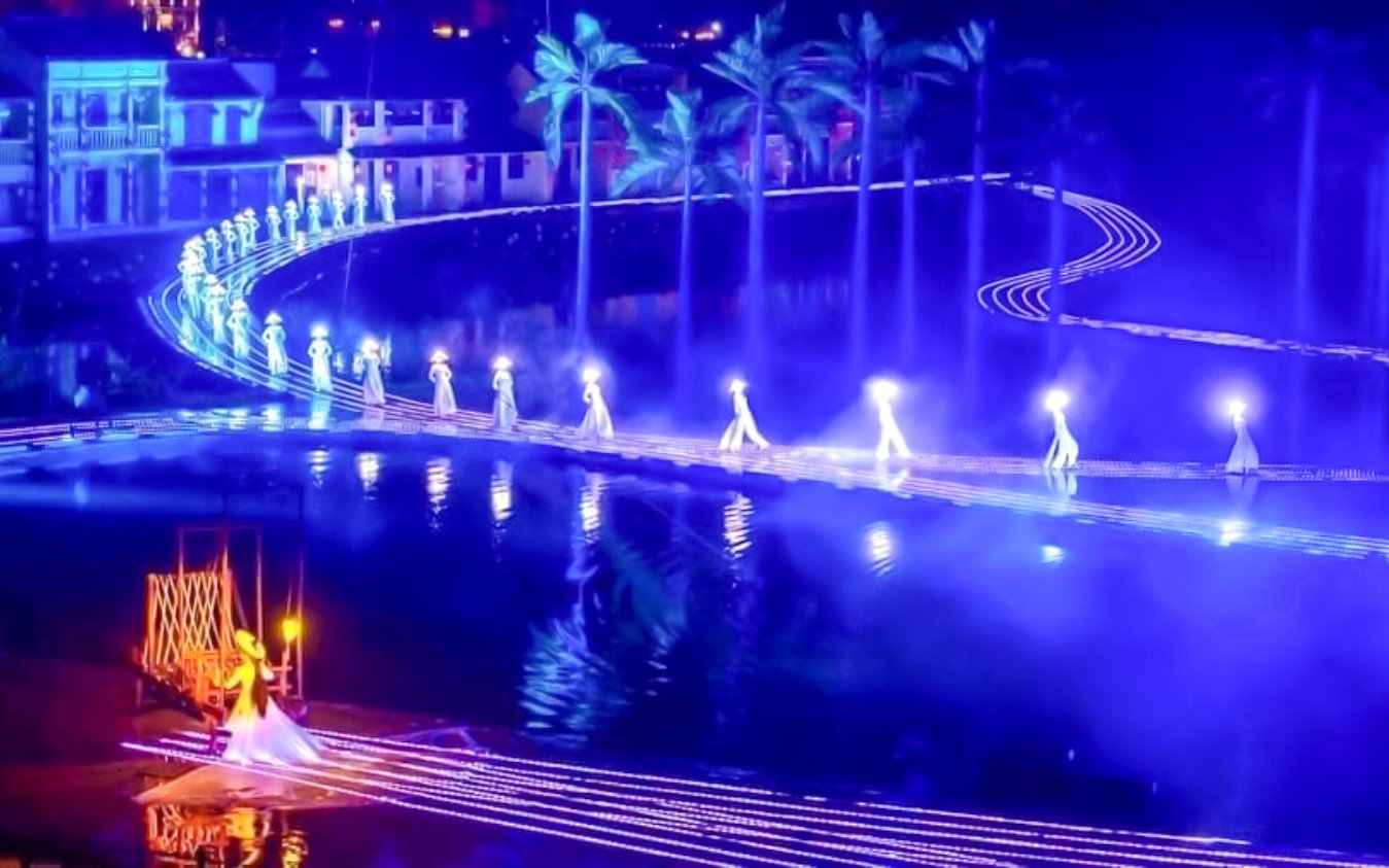 Performers in traditional attire on illuminated stage at Hoi An Memories Show, Vietnam.