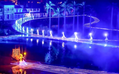 Performers in traditional attire on illuminated stage at Hoi An Memories Show, Vietnam.