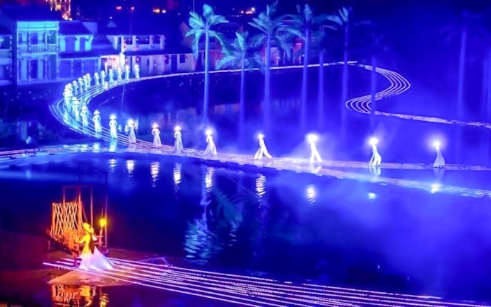 Performers in traditional attire on illuminated stage at Hoi An Memories Show, Vietnam.