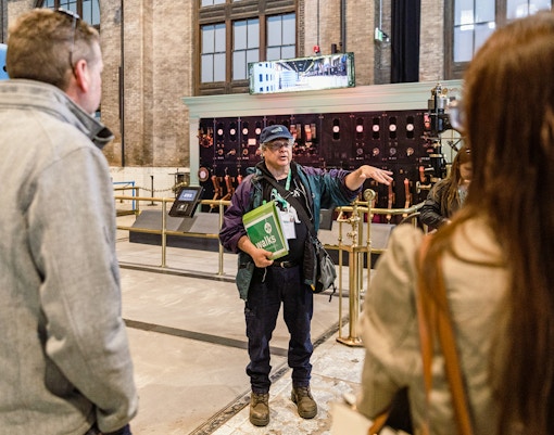 Guide explaining to tourists inside Niagara Power Station, showcasing historical insights.