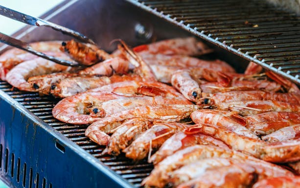 Grilled prawns on a barbecue during Santorini Premium Catamaran Cruise.