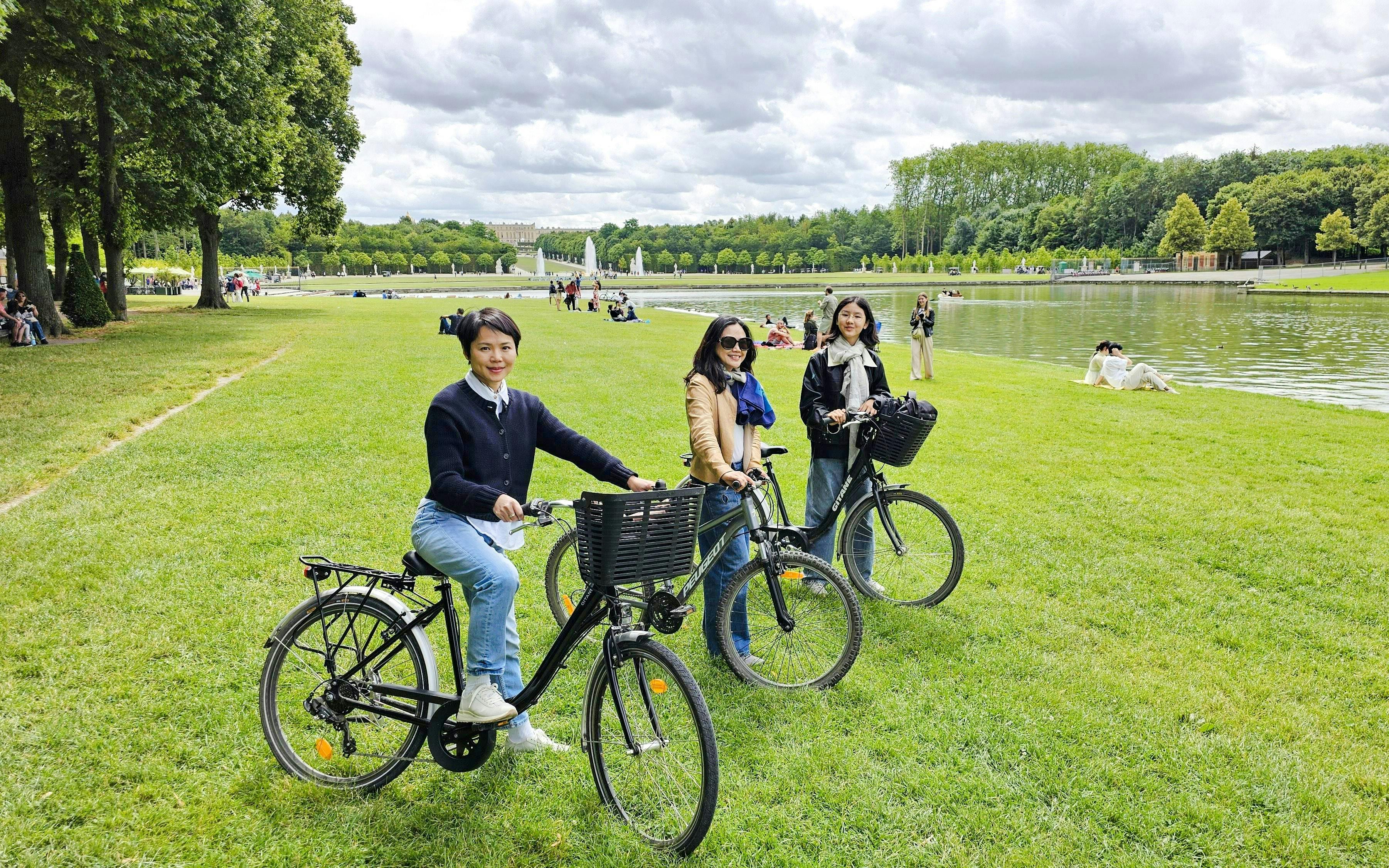 Visitors biking in the gardens of Versailles near the Grand Canal.