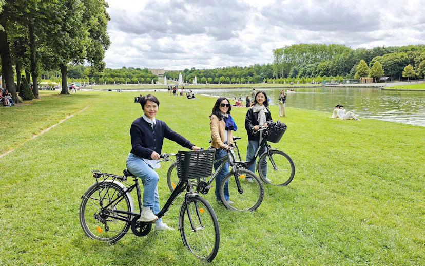 Visitors biking in the gardens of Versailles near the Grand Canal.
