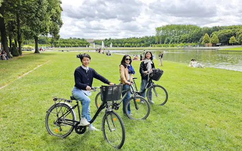 Visitors biking in the gardens of Versailles near the Grand Canal.