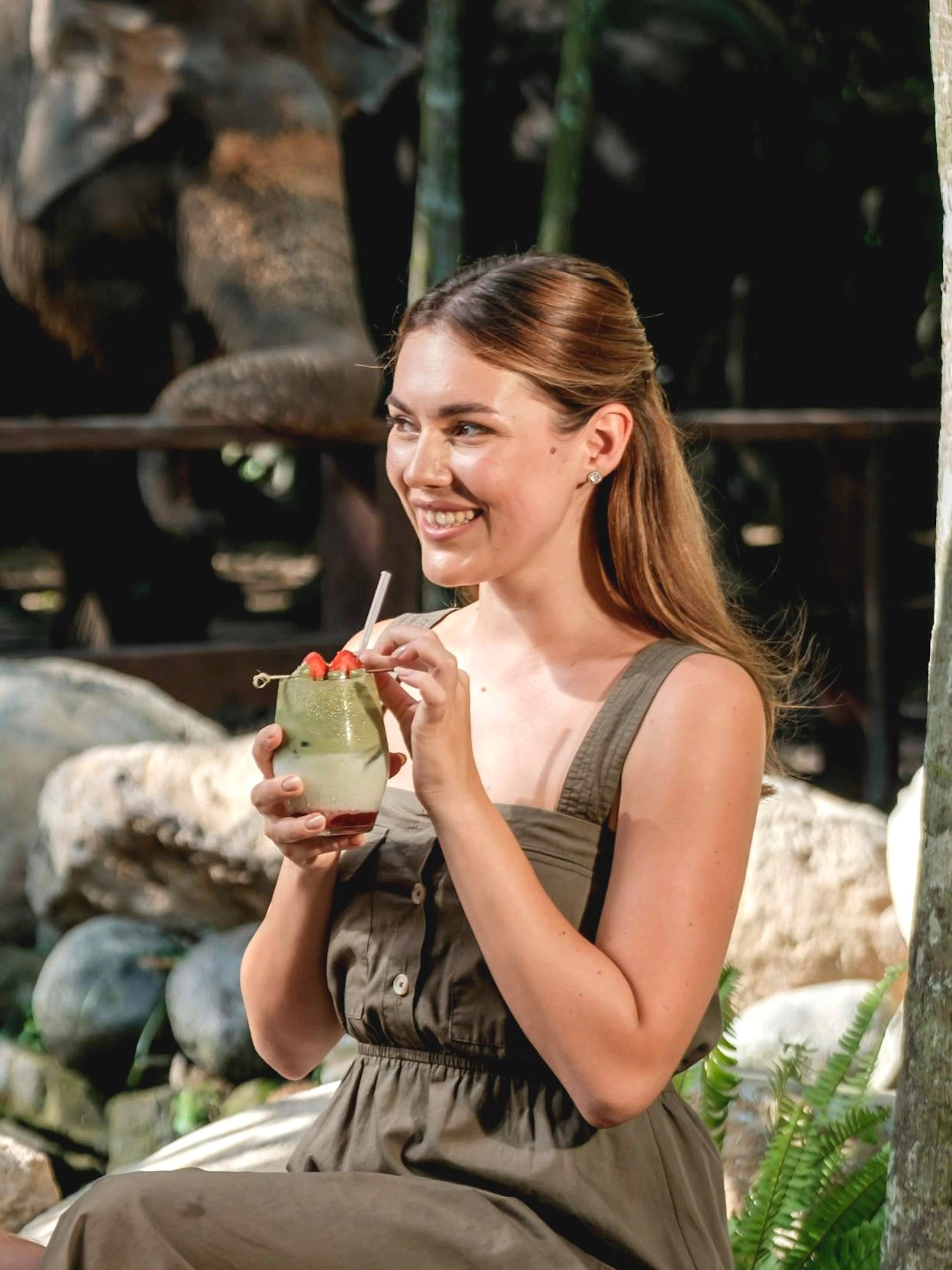 Couple enjoying drinks with elephants in the background at Elephant Explorer Bali.