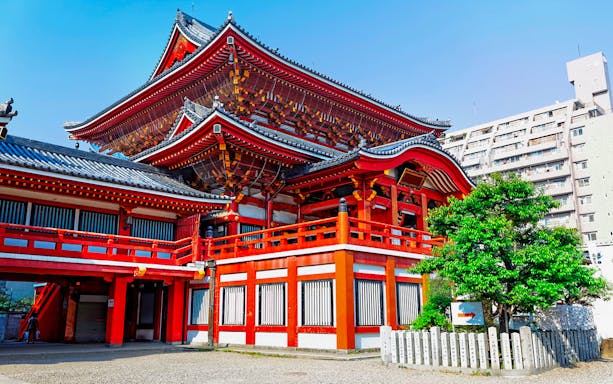 Nagoya Osu Kannon Temple with traditional red architecture and nearby modern buildings.