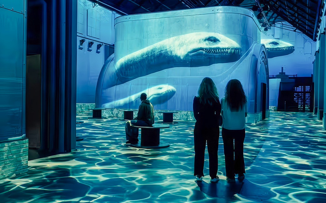 Visitors observing dinosaur projections at Prehistoric Planet: Dinosaurs – The Immersive Experience.