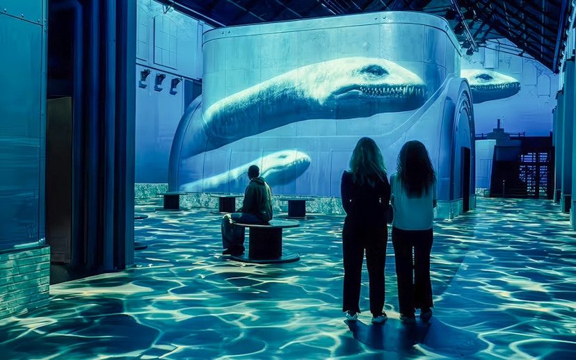 Visitors observing dinosaur projections at Prehistoric Planet: Dinosaurs – The Immersive Experience.