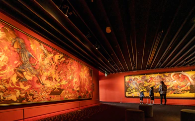 Visitors viewing vibrant murals at Osaka Koji Kinutani Tenku Art Museum.