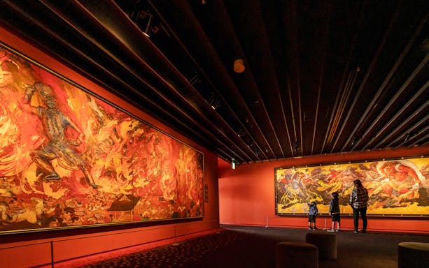 Visitors viewing vibrant murals at Osaka Koji Kinutani Tenku Art Museum.