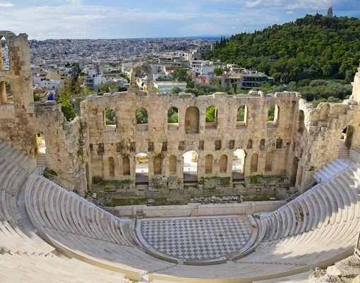 Odeon of Herodes Atticus in Athens with tourists exploring the ancient amphitheater.