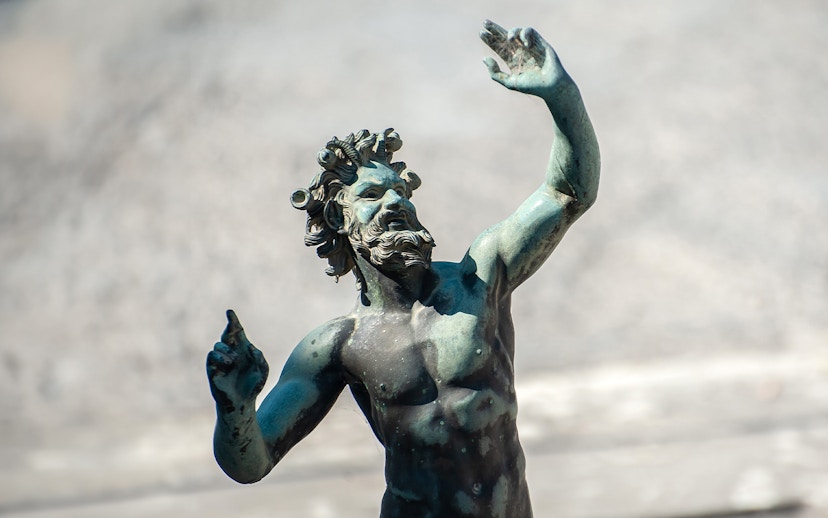 Dancing Faun statue in Pompeii, Italy, depicting a mythological figure in motion.