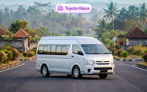 Toyota Hiace van on a scenic road in Bali, available for rental.
