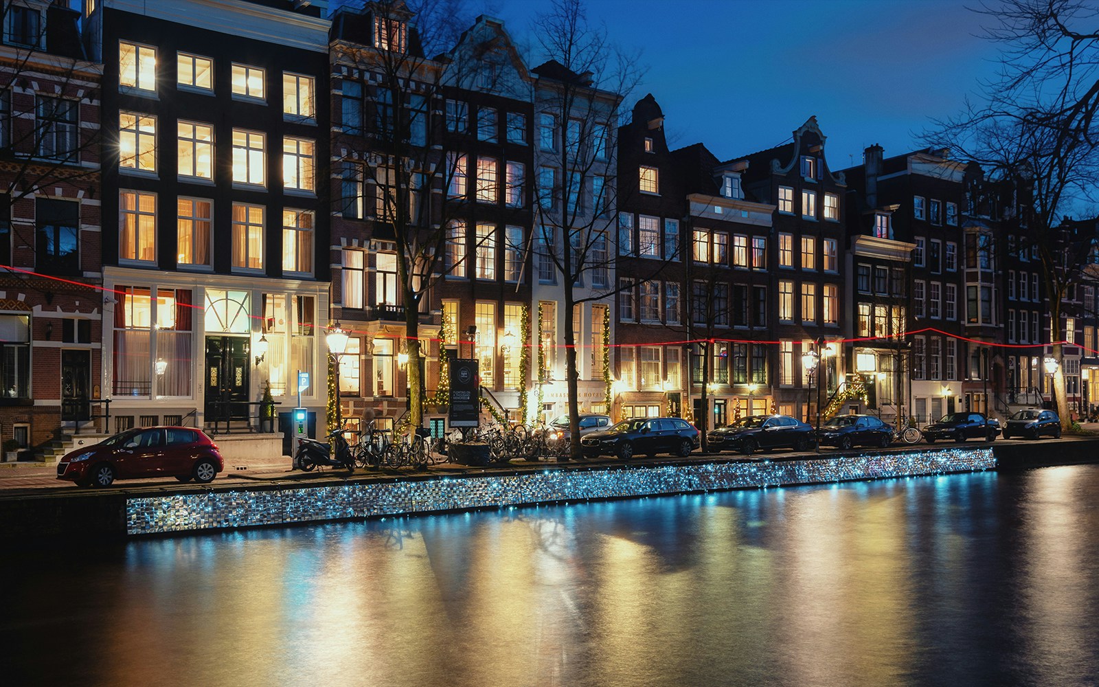 Canal houses along Herengracht in Amsterdam illuminated at night.