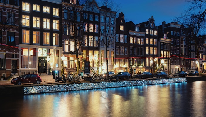 Canal houses along Herengracht in Amsterdam illuminated at night.
