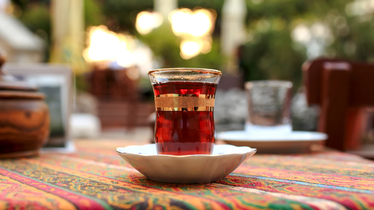 Glass of tea on a colorful tablecloth in an outdoor setting.