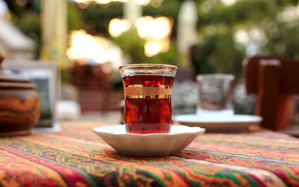 Glass of tea on a colorful tablecloth in an outdoor setting.