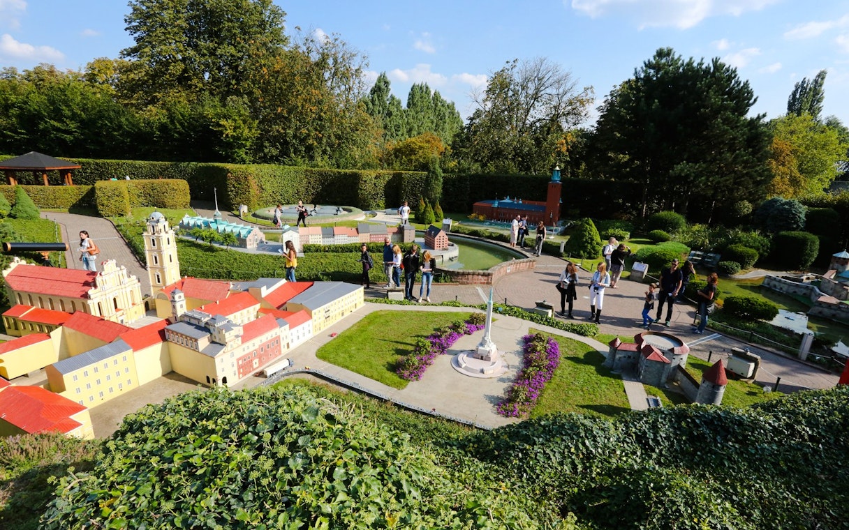 Tourists exploring miniature landmarks at Mini-Europe park in Brussels.