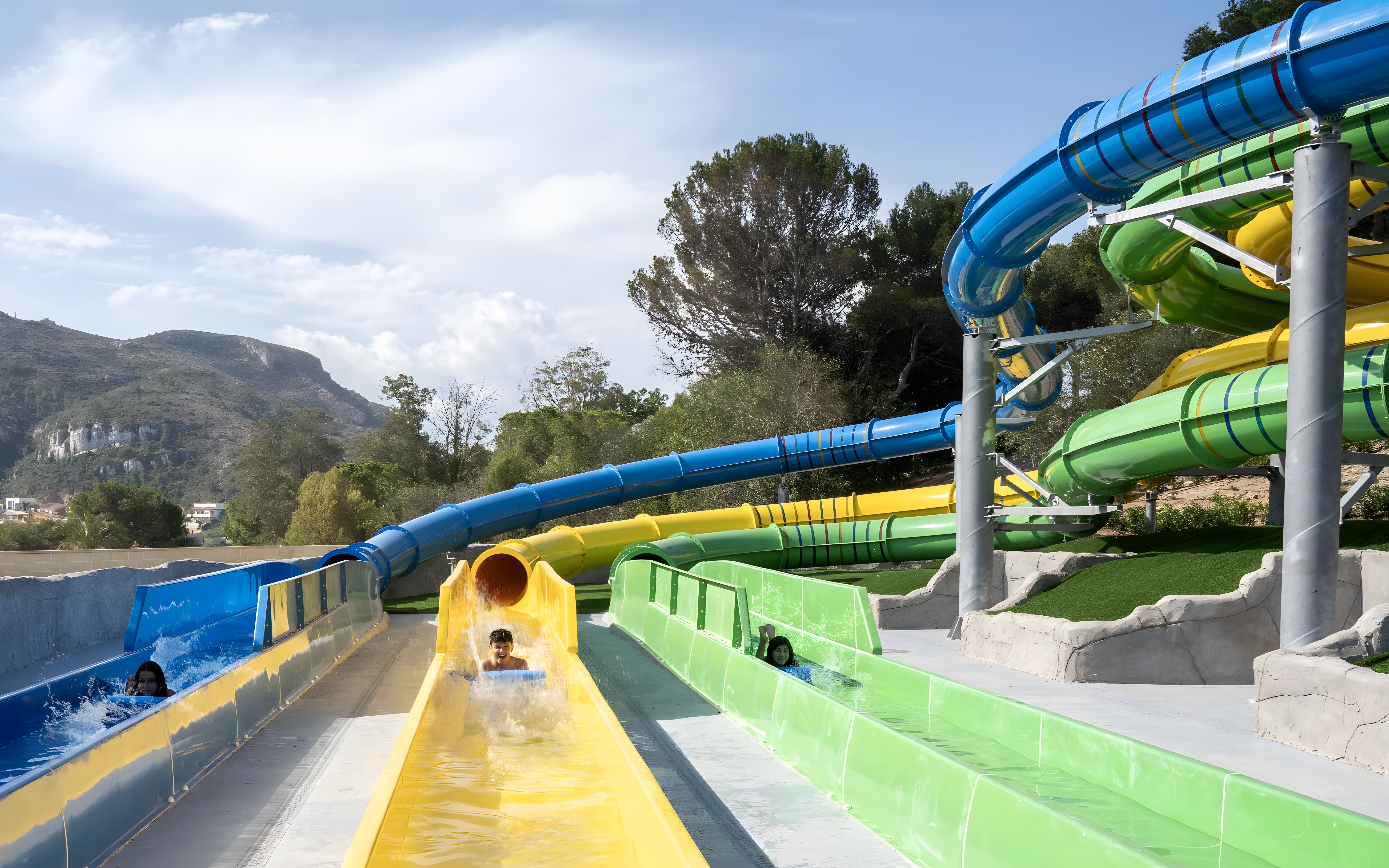 Visitors enjoying the Magic Race slide at Aquopolis Cullera water park.