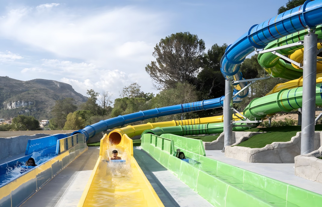 Visitors enjoying the Magic Race slide at Aquopolis Cullera water park.