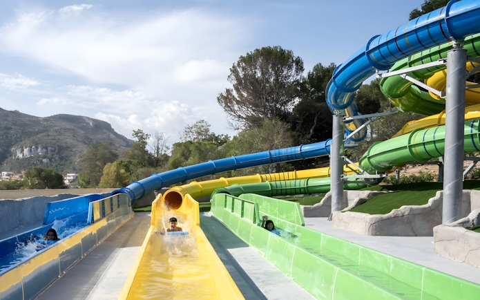 Visitors enjoying the Magic Race slide at Aquopolis Cullera water park.