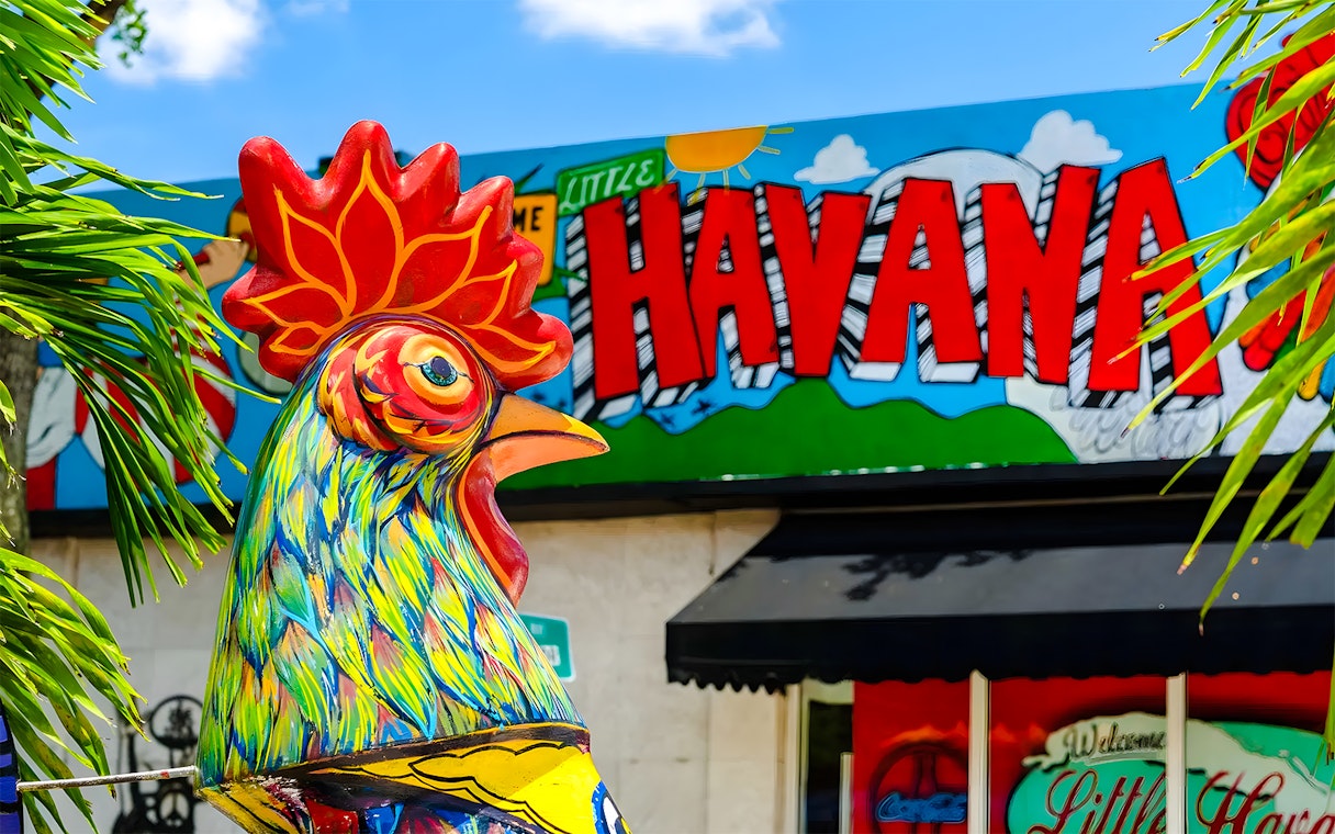 Colorful rooster statue in front of Little Havana mural, Miami.