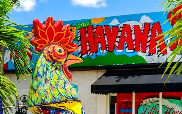 Street view of Little Havana, Miami with colorful murals and people enjoying the vibrant neighborhood.
