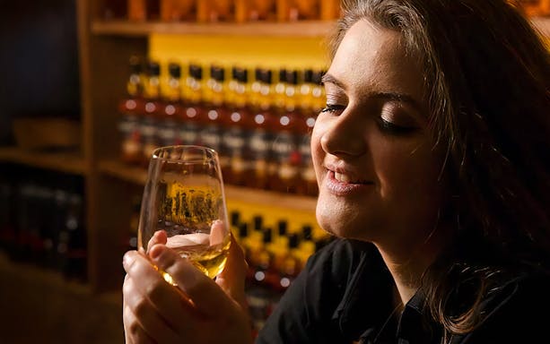 Guest holding a glass of whiskey at the Irish Whiskey Museum in Dublin, Ireland.