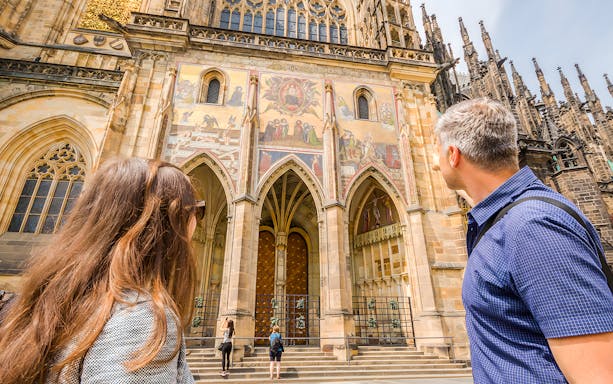 Visitors admiring the ornate facade of St. Vitus Cathedral on a Prague Castle guided tour.