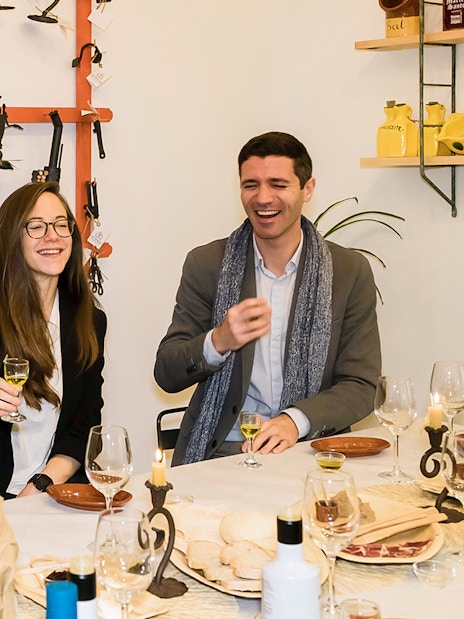 Group enjoying tapas and drinks at a table in Seville during a tasting tour.