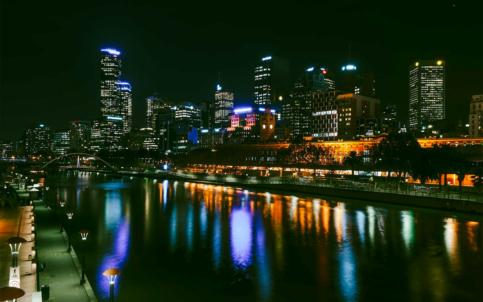 Melbourne city skyline at night with Yarra River reflections.