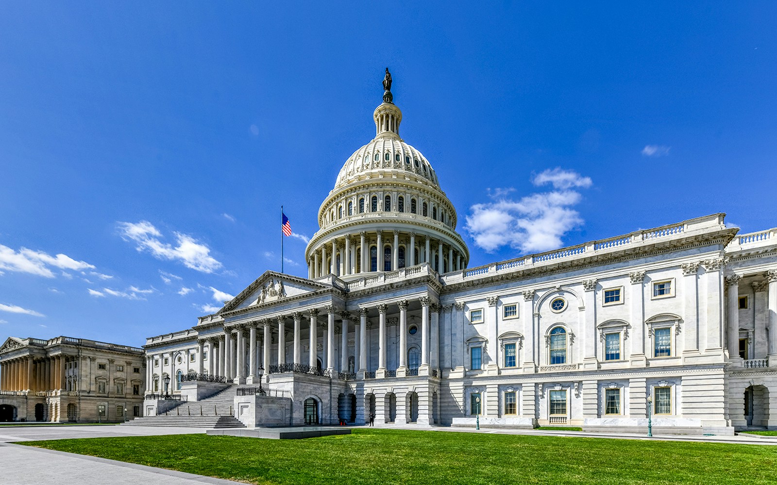 US Capitol Building with dome and American flag, Washington, DC.