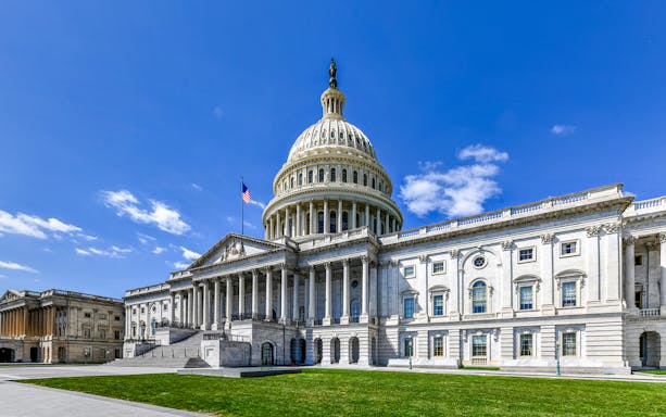 US Capitol Building in Washington, DC with iconic dome and surrounding greenery.