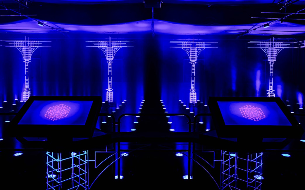 Interactive digital display at AMAZE Amsterdam Immersive Experience with blue neon lights.