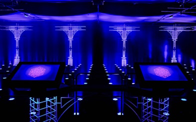 Interactive digital display at AMAZE Amsterdam Immersive Experience with blue neon lights.