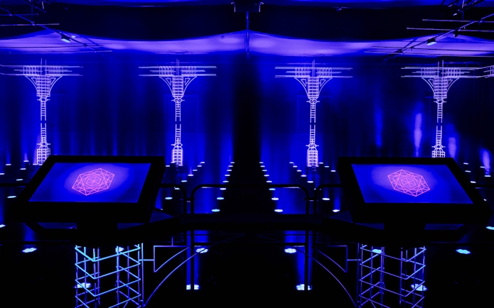 Interactive digital display at AMAZE Amsterdam Immersive Experience with blue neon lights.