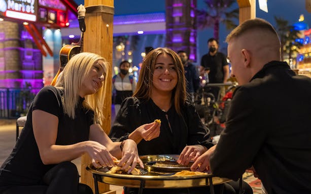 Dining at Global Village Dubai with friends enjoying local cuisine.