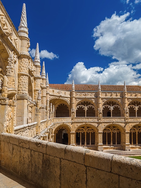 Jeronimos Monastery cloister with ornate arches in Lisbon, Portugal.