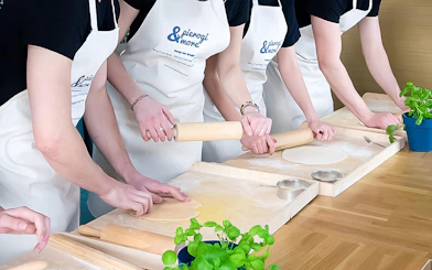 Participants rolling dough in a Polish dumplings cooking class.