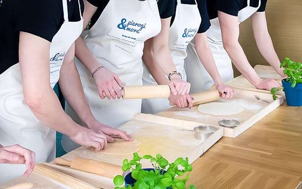 Participants rolling dough in a Polish dumplings cooking class.