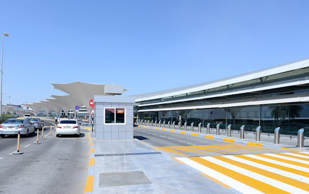 Abu Dhabi Airport terminal entrance with cars arriving, related to one-way tickets from/to Dubai.