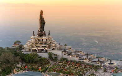 Ba Den Mountain temple complex with large statue at sunset, Tay Ninh, Vietnam.