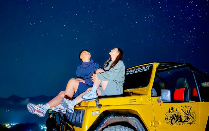 Couple stargazing from jeep during Mount Batur trip.