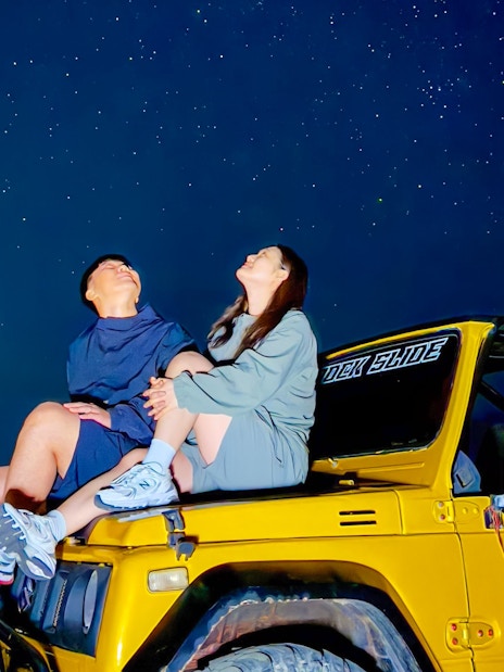 Couple stargazing from jeep during Mount Batur trip.