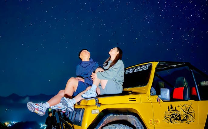 Couple stargazing from jeep during Mount Batur trip.