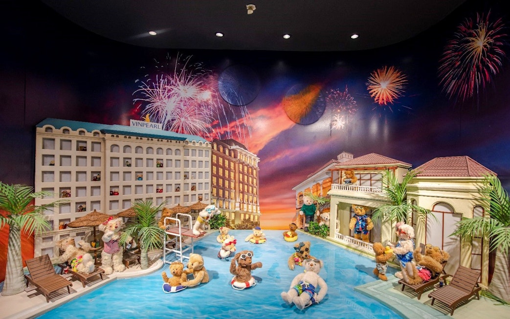 Teddy bears enjoying a pool scene with fireworks at the Teddy Bear Museum.